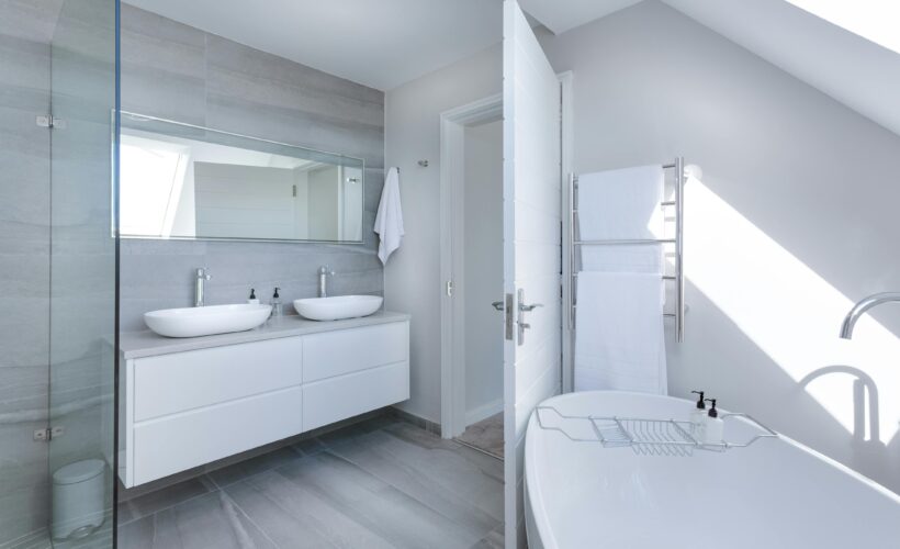 Sleek contemporary bathroom with bathtub and twin sinks, showcasing minimalist design and luxury.